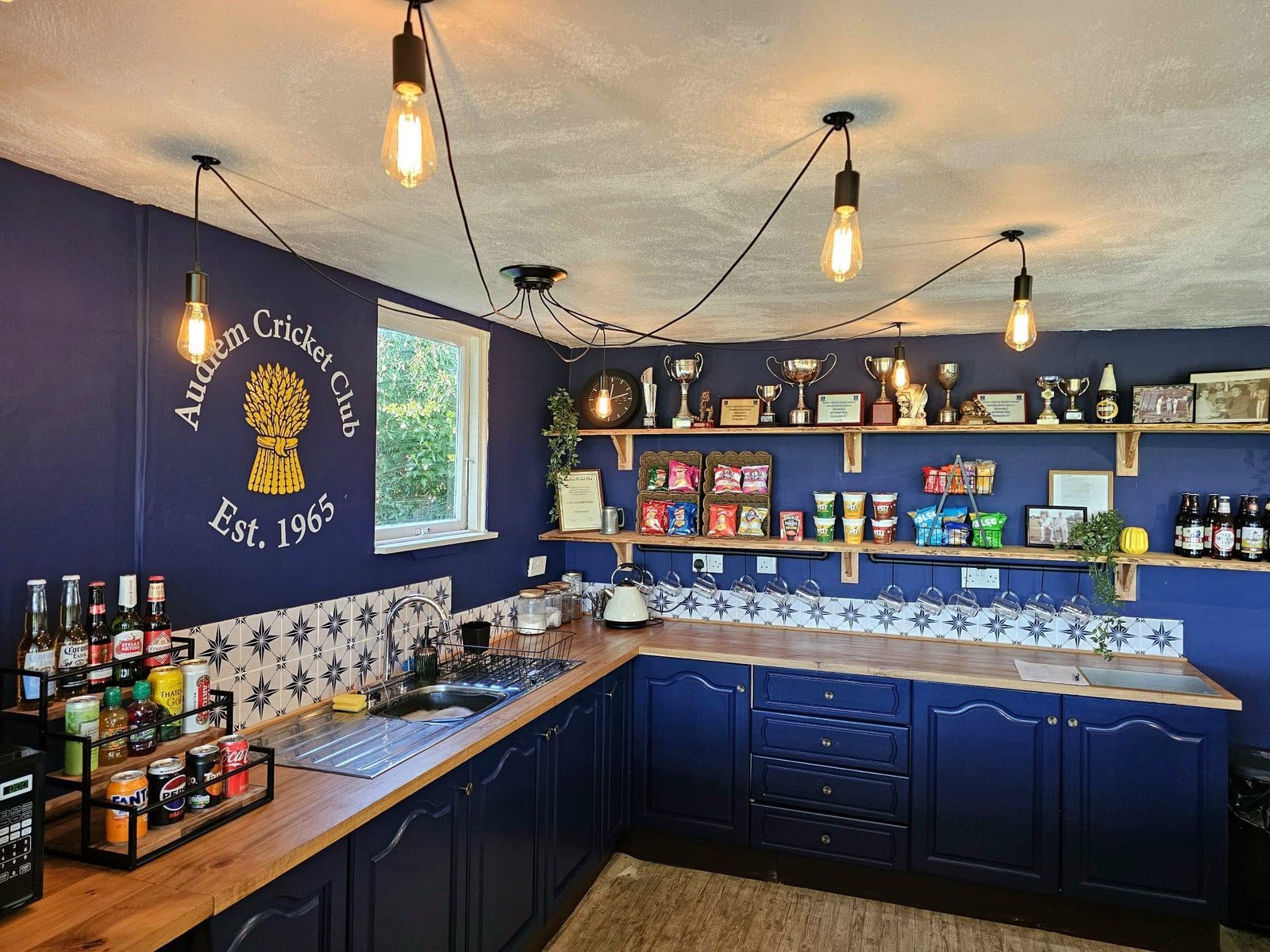 Audlem Cricket Club bar after refurb — club crest, navy cabinets and trophy shelves
